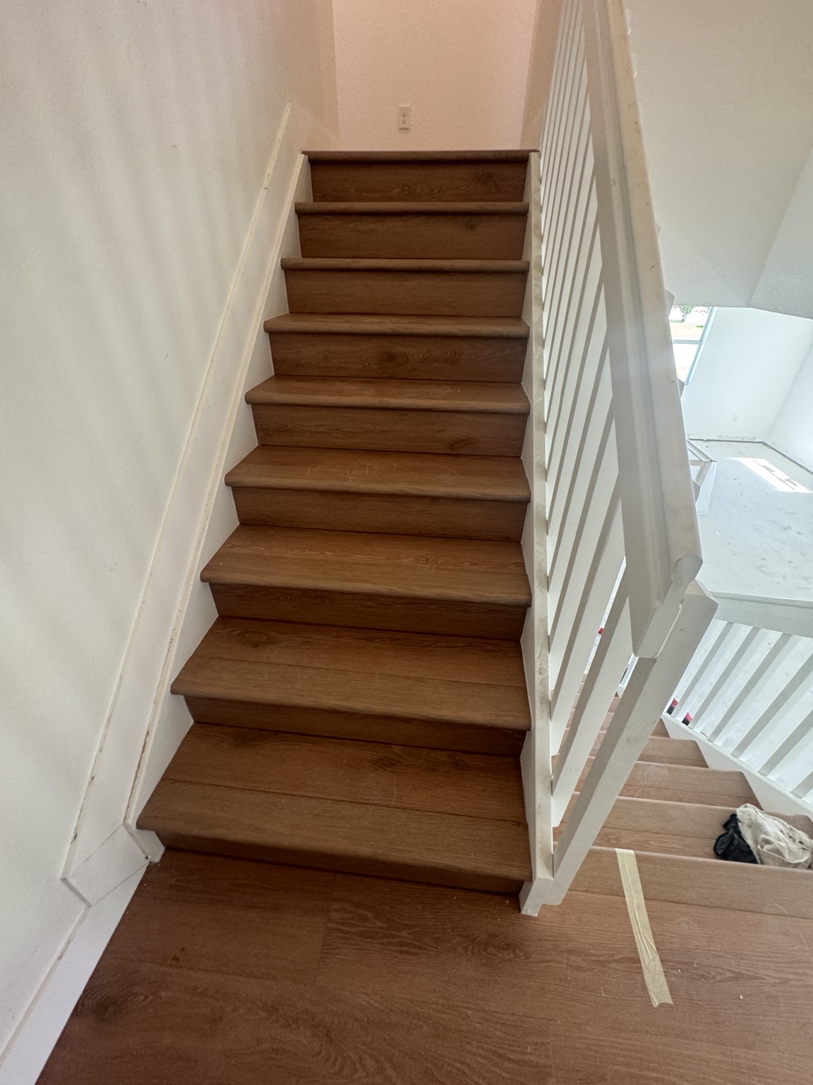 Front view of finished staircase with warm oak laminate treads coordinated with the floors