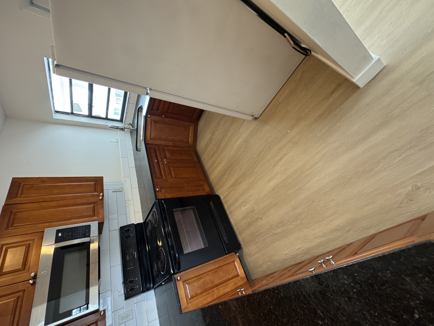Same kitchen after installing floating vinyl plank directly over the existing tile