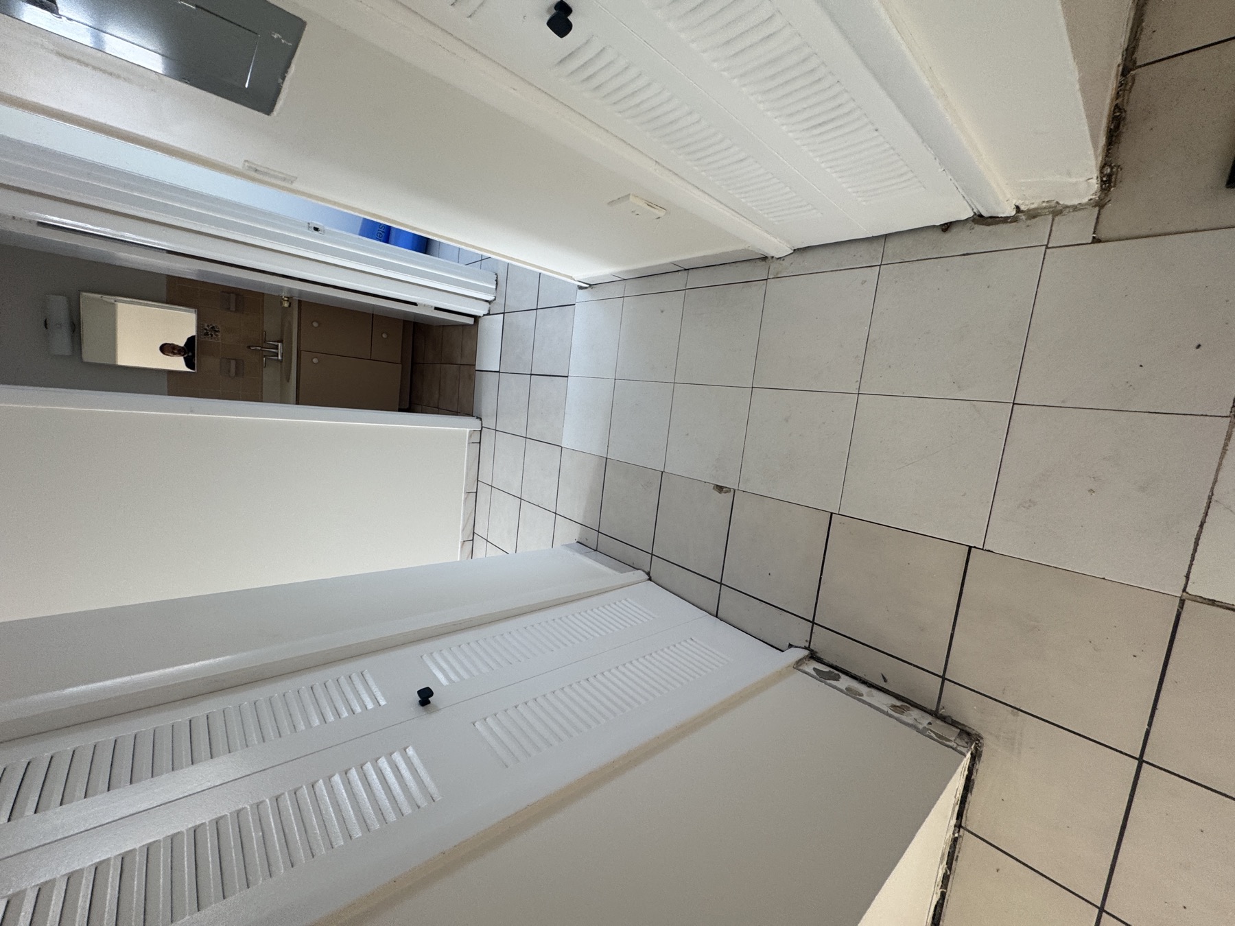 Apartment hallway with existing tile before floating floor installation