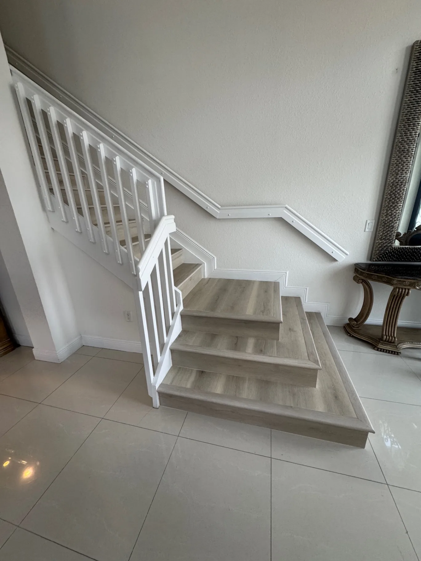 Completed staircase — wide angle view showing the light gray wood-look finish and the extended lower steps.